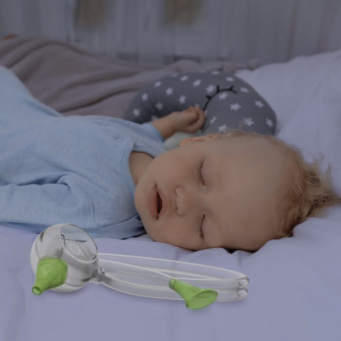 Un bébé dort paisiblement à côté d'un mouche-bébé manuel Nosiboo Eco