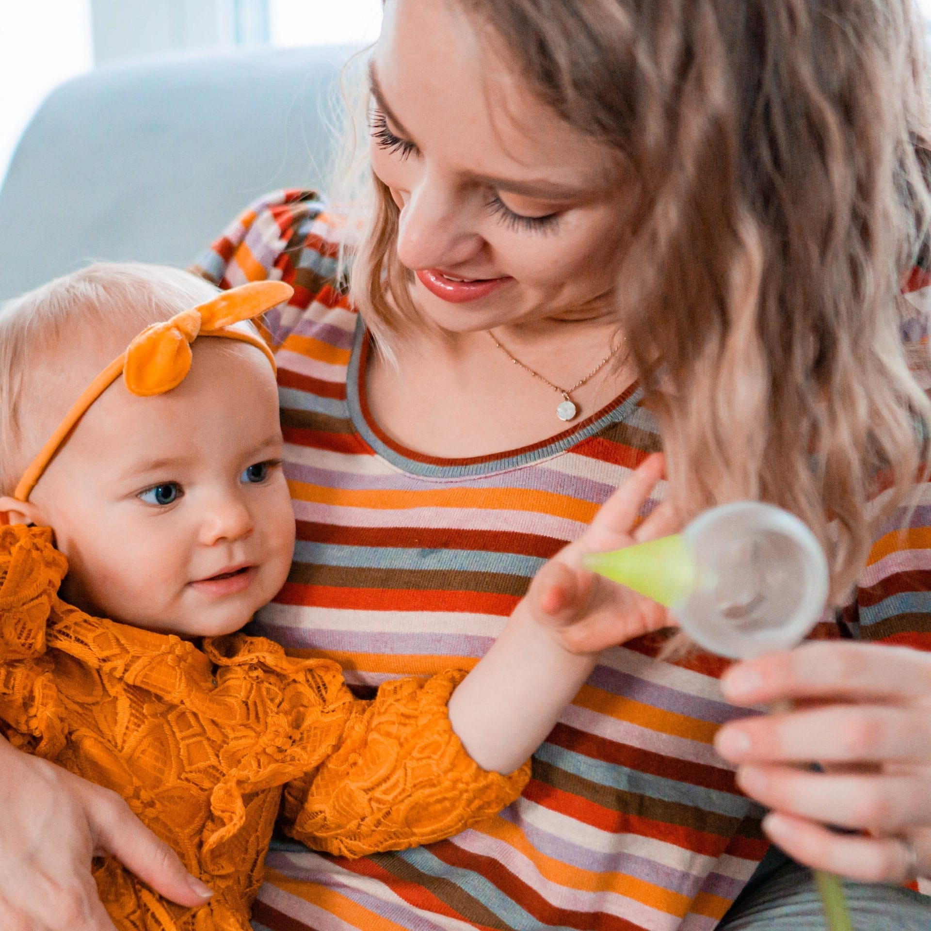 Une mère avec sa fille, tenant un mouche-bébé électrique Nosiboo Pro
