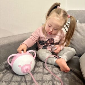 Une mère avec son fils assis par terre et utilisant le mouche-bébé électrique Nosiboo Pro.
