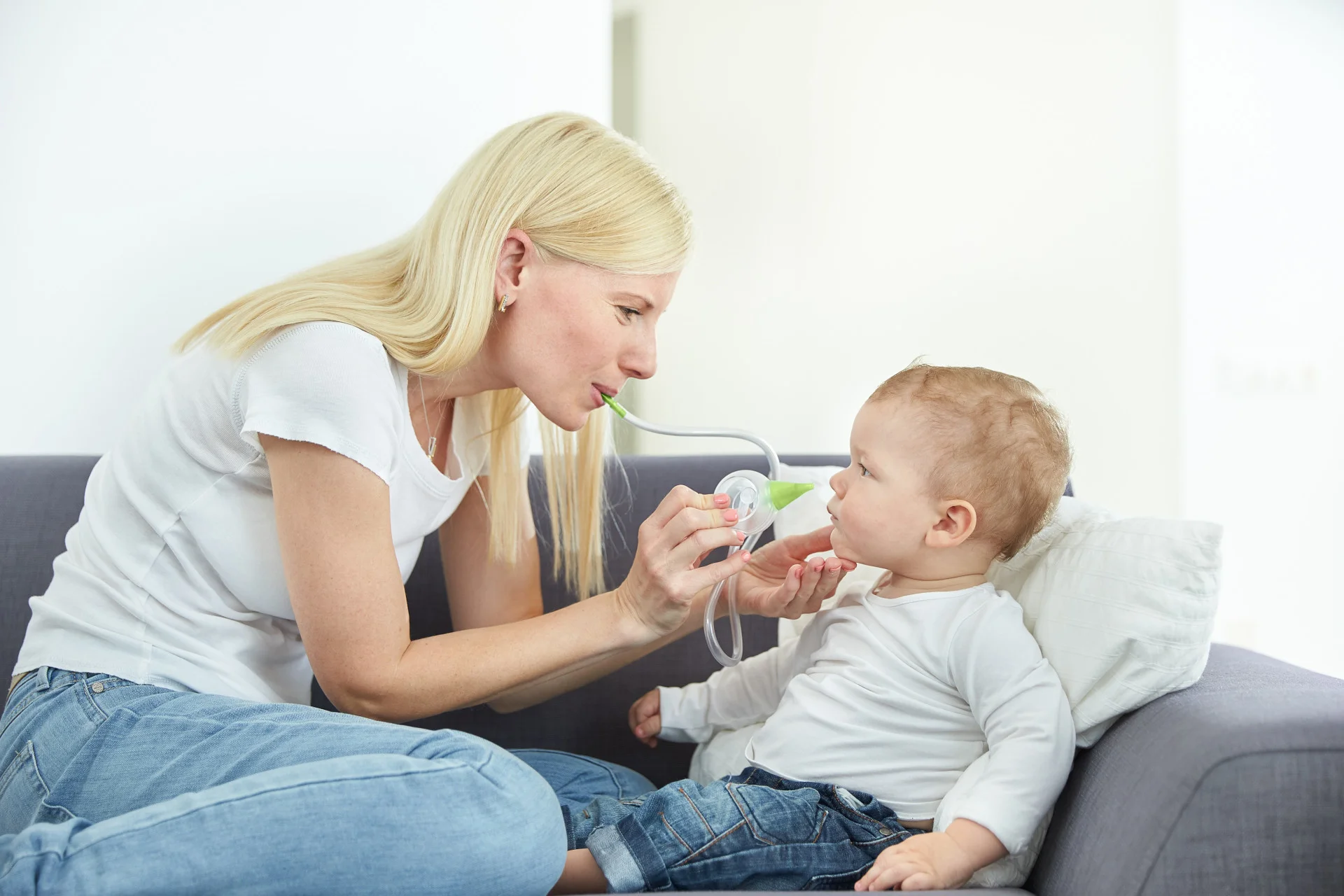 Une mère nettoie le nez de son petit à l'aide du mouche-bébé manuel Nosiboo Eco