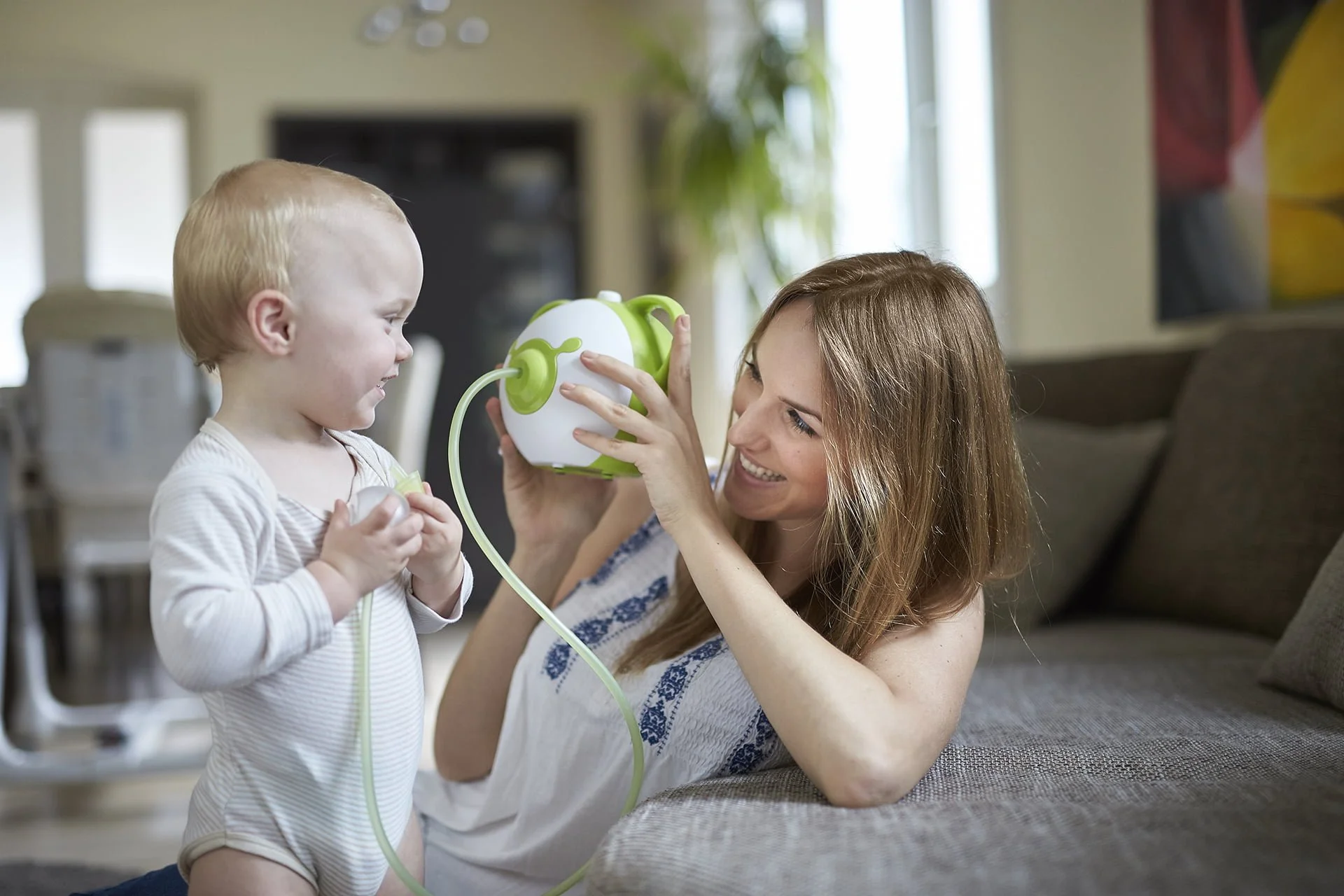 Afficher une photo en taille réelle d'un bébé et une mère heureux avec un mouche-bébé électrique Nosiboo Pro