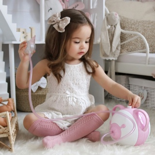 Une petite fille élégante dans sa chambre avec un mouche-bébé électrique Nosiboo Pro rose