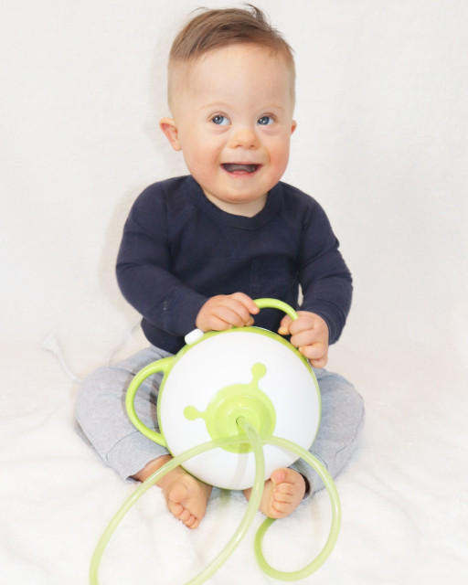 Petit garçon souriant tenant un mouche-bébé électrique Nosiboo Pro vert