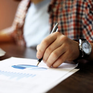 Un homme prend des notes sur un papier avec un diagramme.